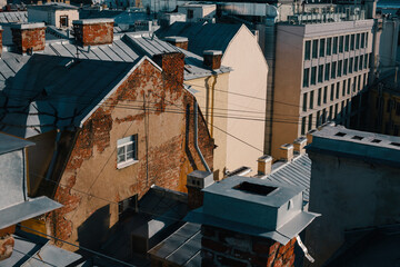 Wall Mural - Old brick house with tin roof and many pipes, view from rooftop, walk on the roofs