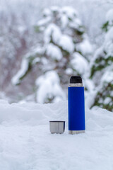 Blue thermos bottle on snow.