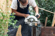 Worker using circular saw for wood works