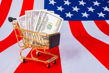 Poster - Shopping trolley with dollar bills on background of USA flag. Shopping cart financial concept. Shopping trolley symbolizes USA trade. Dohoot from America commodity circulation. US export earnings.