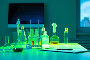 Poster - Many different test tubes at laboratory table. Clipboard on laboratory assistant table. Glass test tubes of various shapes. Lab test tubes with chemical liquid. Concept - sale of laboratory equipment