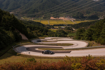 Canvas Print - The curious rounding road at the deep valley.