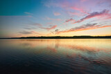 Fototapeta Niebo - Sun sets over a lake in Mazury, Poland.