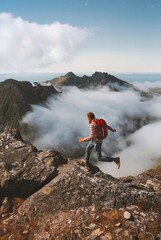 man trail running in mountains on cliff above clouds solo travel hiking adventures activity outdoor 