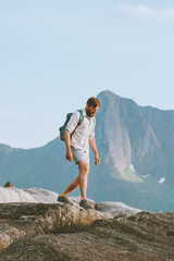 Wall Mural - Man tourist hiking solo traveling in Norway vacations eco tourism in mountains outdoor adventure active healthy lifestyle summer shorts clothing