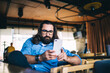 © BullRun - Serious man checking smartphone in cafe