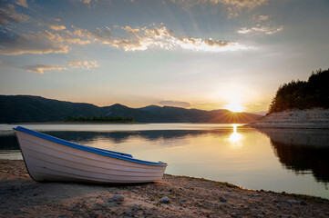 Naklejka na meble Sunset over a dam in Bulgaria with a white fishing boat