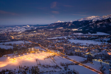 Wall Mural - Breathtaking illuminated Zakopane after sunset in winter, aerial view