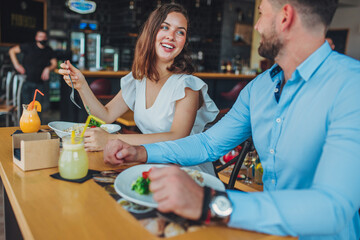 Loving couple eating together at restaurant.