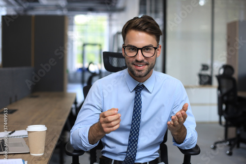 Confident business man looking at camera talking about company strategy and business plan, explaining corporate success Poster Mural XXL