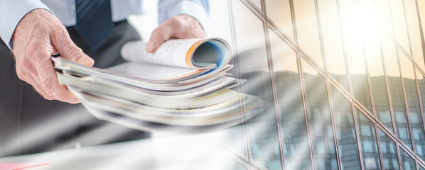 Businessman holding magazines; multiple exposure