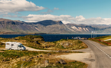 Leinwandbilder - Sunny landscape with asphalt road and perfect sky in Iceland. Great Icelandic nature scenery. Typical Icelandic seascape with houses against mountains in small village of Arnarstapi village. Iceland