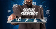 © ra2 studio - Young business person working on tablet and shows the inscription: SOCIAL STATISTICS