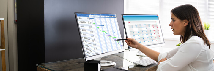 Poster - Employee Working On Calendar Schedule