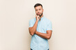 © Asier - Young south-asian man looking sideways with doubtful and skeptical expression.