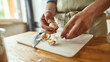 © Svitlana - Close up of hands of man in apron peeling garlic while preparing a meal in the kitchen. Cooking at home concept