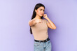 © Asier - Young indian woman isolated on purple background throwing a punch, anger, fighting due to an argument, boxing.