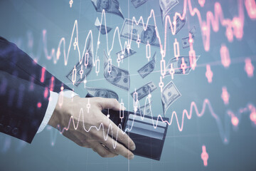 Multi exposure of financial graph drawing hologram and USA dollars bills and man hands. Analysis concept.