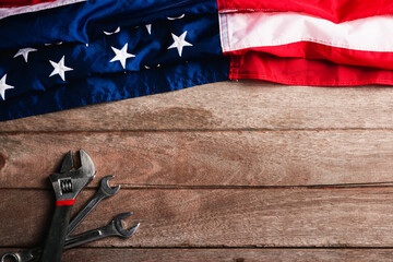 USA Labor day concept, Top view flat lay of different kinds wrenches with American flag on wood table. First Monday in September, creation of labor movement and dedicated to social of American worker