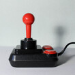 alter schwarzer klassischer Joystick mit roten Druckknöpfen
