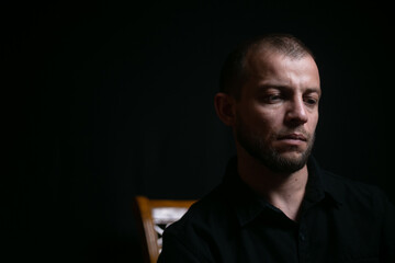 sad guy sitting on black background