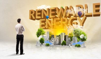 Rear view of a businessman standing in front of RENEWABLE ENERGY inscription, Environmental protection concept