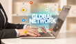 © ra2 studio - Freelance woman using laptop with GLOBAL NETWORK inscription, Social media concept