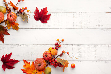 Wall Mural - festive autumn decor from pumpkins, berries and leaves on a white wooden background. concept of than