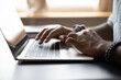 © fizkes - Close up African American male hands typing on laptop keyboard, businessman manager freelancer working on online project, sitting at work desk, using computer, man chatting, browsing apps