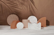 © kopikoo - 3D beige pedestal podium set, palm tree leaf shadow over brown natural background. Geometric shape, white marble summer display showcase for beauty cosmetics products. Abstract 3d render illustration