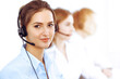 © rogerphoto - Call center operators. Focus on beautiful business woman using headset in sunny office