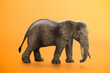 © Maksims - Miniature elephant animal toy on orange background