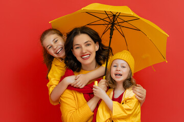 Wall Mural - Family with umbrella on colored background.