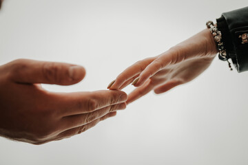 A gentle touch of the hands of a man and a woman on a white background. Love connection help concepts. Be hand in hand.