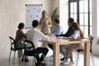 © fizkes - Focused young multiracial diverse employees listening to older 60s skilled female team leader, presenting marketing strategy or corporate growth plan near flipchart at workshop in office meeting.