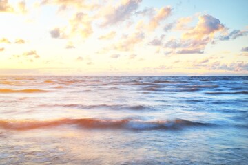 Wall Mural - Epic colorful glowing pink sunset clouds above the sea after a thunderstorm. Dramatic sky. Waves and water splashes texture. Idyllic seascape. Concept image, long exposure. Picturesque scenery