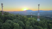 Transmission Towers 4G/5G Cell Phone Masts On Country Hillside At Sunset, Aerial