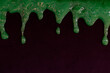 Green goo runs down the black wall. Halloween decor. Space for text, copy space. The photo