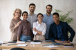 Group portrait of happy motivated multiracial different generations business people with young arabian female company leader in center, successful international dream team looking at camera in office.