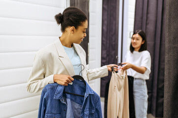 Wall Mural - Smiling girls in fitting room, clothing store