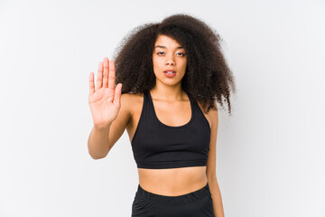 Young african american sporty woman standing with outstretched hand showing stop sign, preventing you.