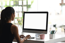 A Woman Is Using A Mockup Computer With Empty Screen On Modern Workspace.