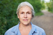 © amixstudio - Close-up portrait of beautiful gray-haired elderly woman smiling on the background of a summer forest park
