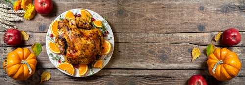 Baked chicken for Thanksgiving Day. Roasted chicken or turkey with citrus and spices for celebrations thanksgiving day on wooden table. Festive table settings for thanksgiving dinner. Copy space