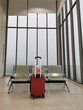 © ake - safe travel in virus pandemic time.  passenger waiting area in transportation terminal keeping seat apart with the red luggage.  social distancing new normal concept.