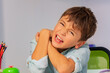 Close portrait of a boy with autistic disorder breaking hands and fingers in negative expression behavior during development therapy class lesson