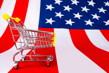 Poster - An empty shopping cart and an American flag. Trade in the United States. Purchases in American online stores. Ordering products in the United States. Data on supply and demand in America.
