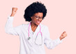 Young african american woman wearing doctor coat and stethoscope dancing happy and cheerful, smiling moving casual and confident listening to music