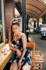 Wall Mural - Attractive young caucasian woman sitting in street cafe