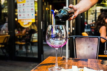 waiter filling red wine to a red wine glass